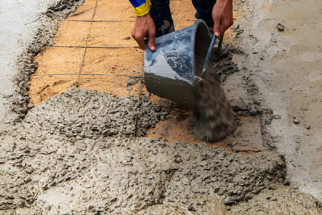 builder is pouring concrete floor construction